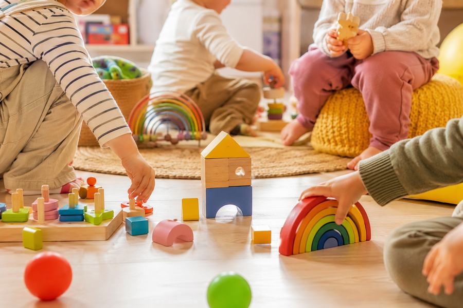 Niños jugando con bloques de madera y juguetes de colores