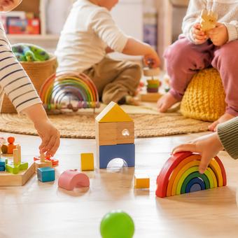 Niños jugando con bloques de madera y juguetes de colores